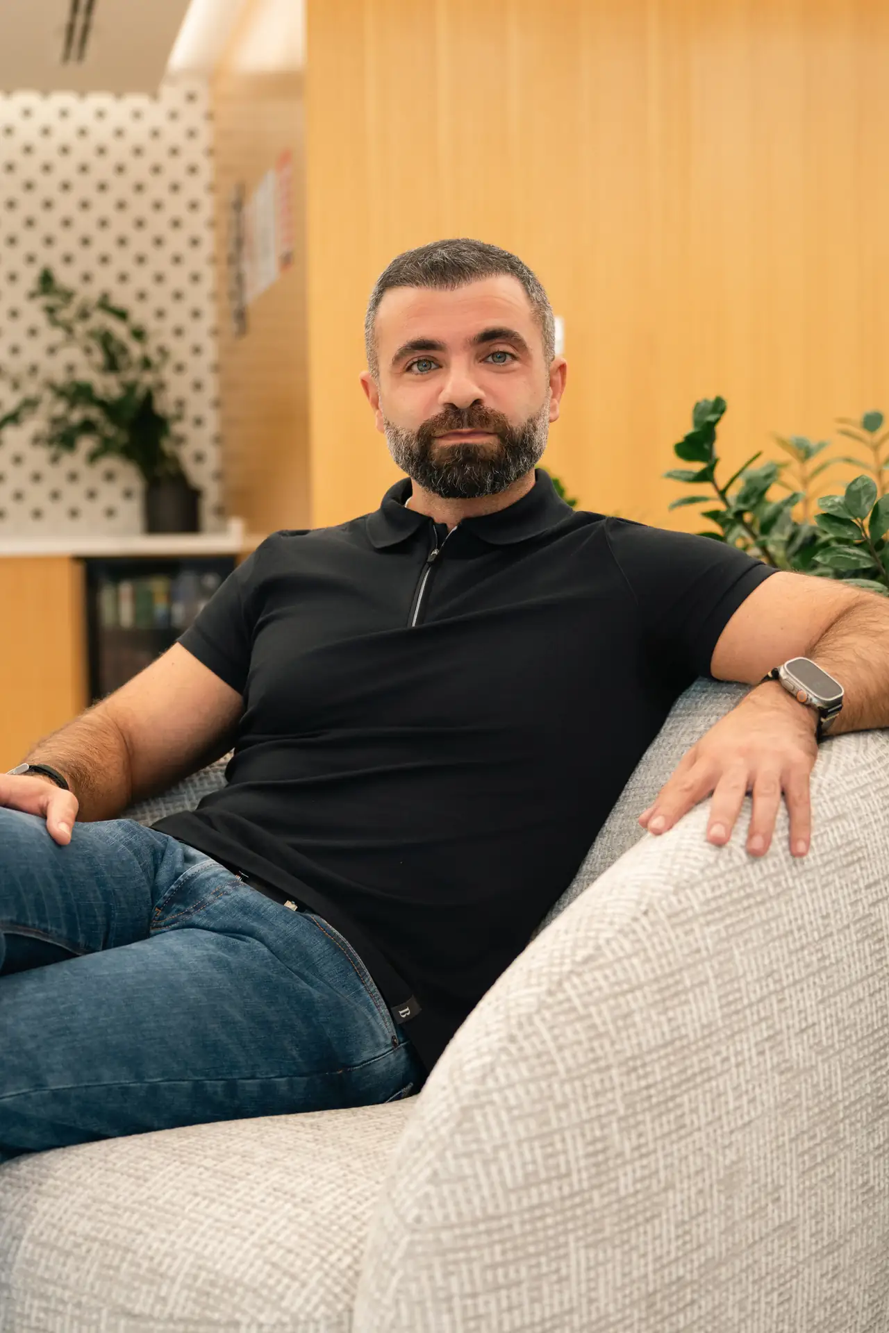 Casual seated portrait in a polo shirt in the office lounge. On-site corporate headshot at the Nutanix office in Dubai.