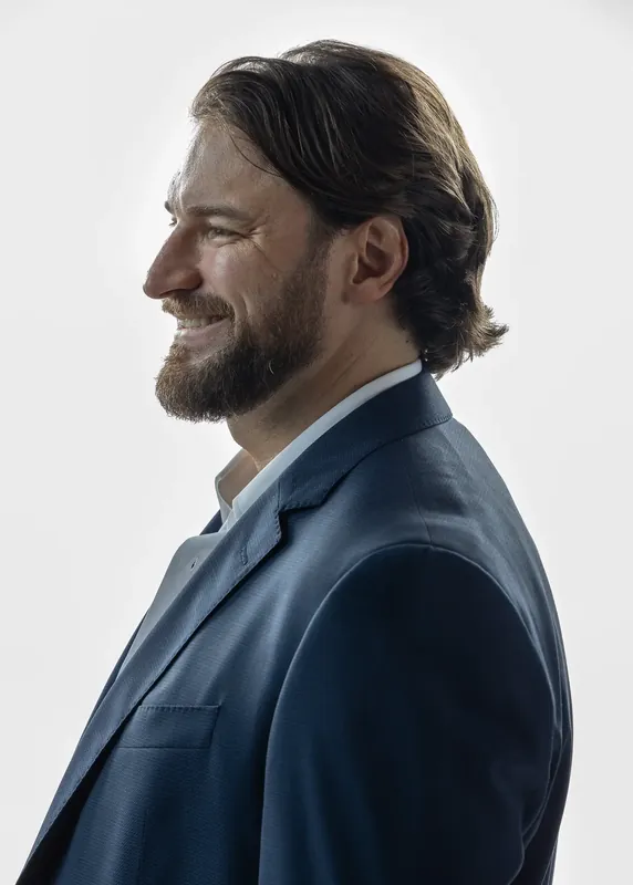 Left side profile with a smile. White background reference photo from an AI model training photoshoot at the MRPS studio in Dubai.