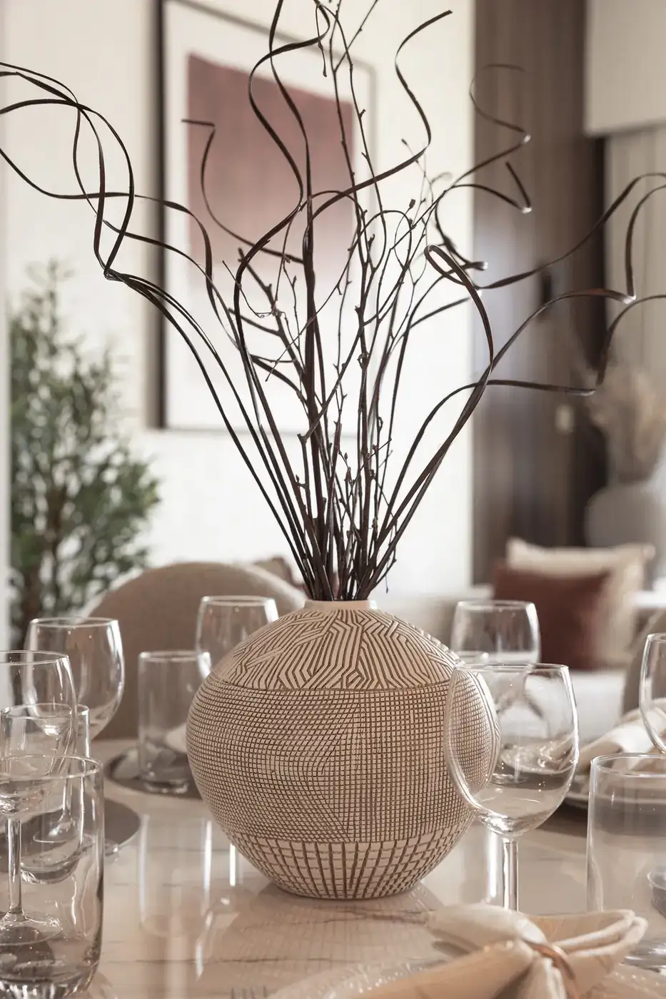 Dining table centrepiece with a woven vase and curly branches. Interior design photography for Aziza Home by MRPS in Dubai.
