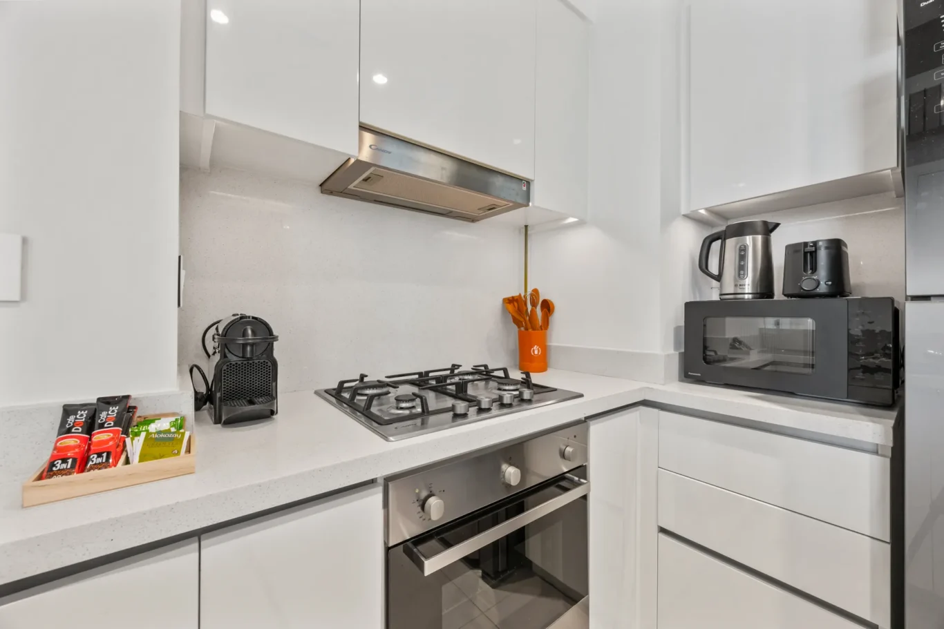 Kitchen counter with gas hob, oven, coffee machine and microwave. Day, twilight and night Airbnb photography by MRPS for Vista Haus Holiday Homes in Downtown Dubai.