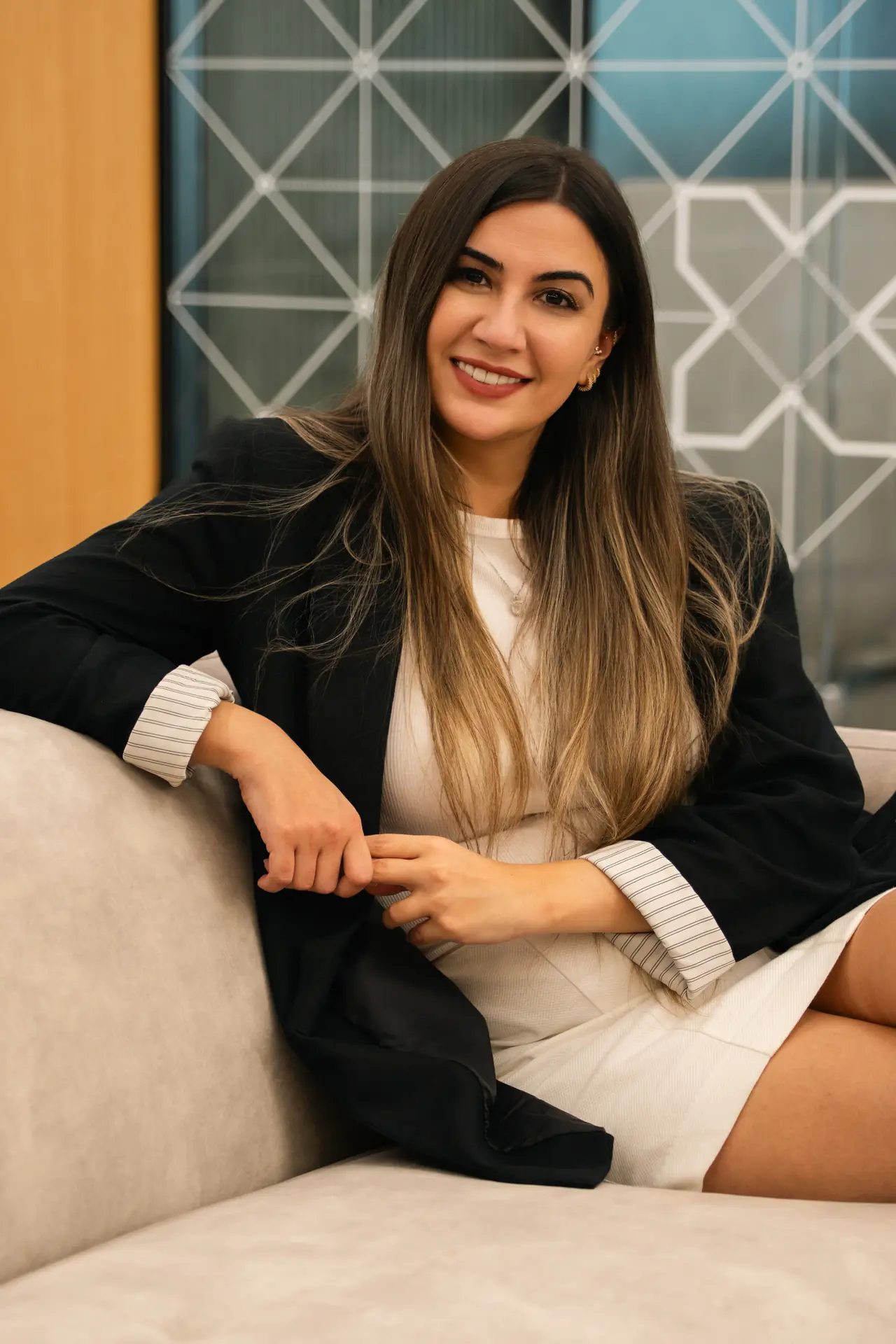 Seated portrait in a black blazer on the lounge sofa. On-site corporate headshot at the Nutanix office in Dubai.