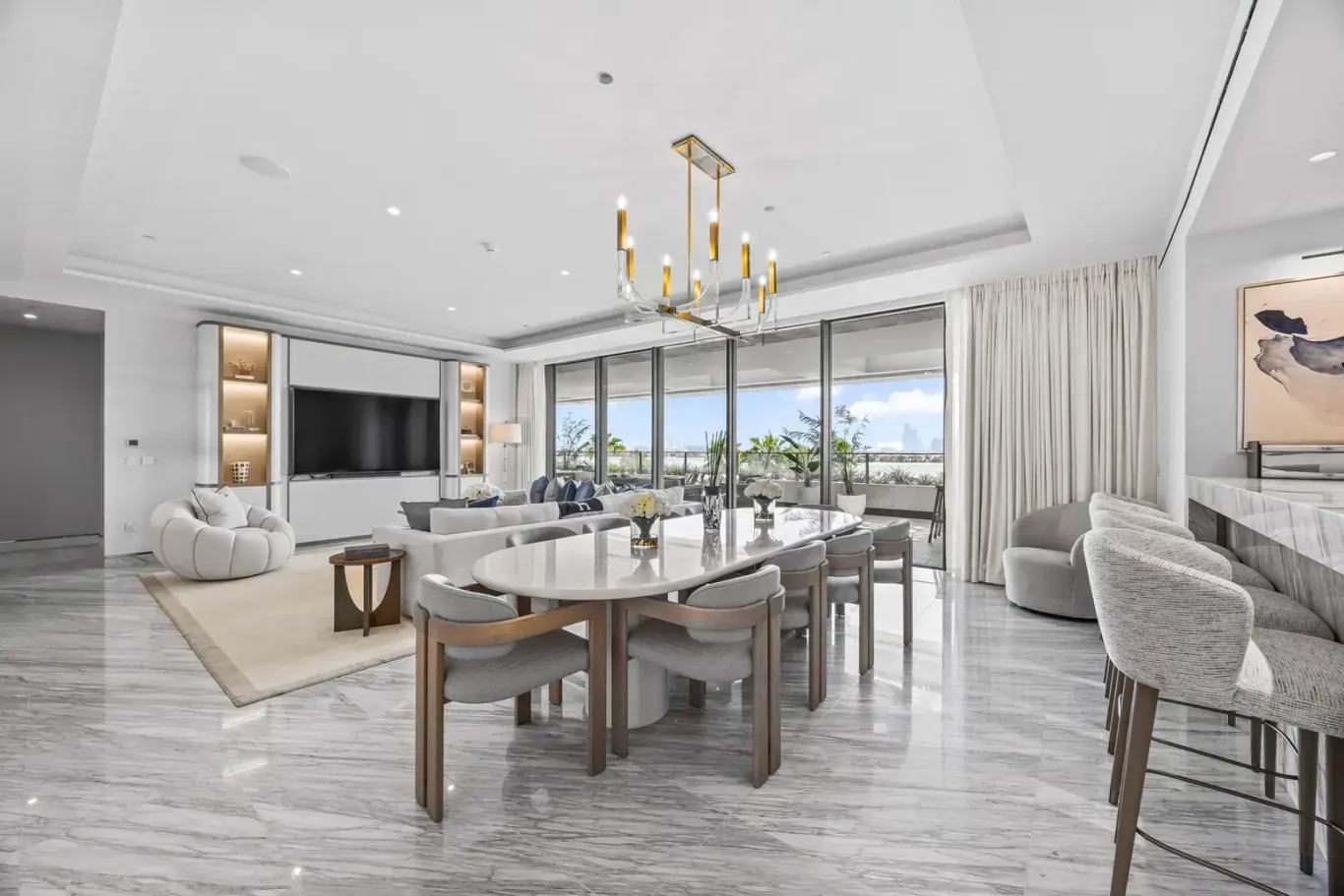 Dining table for eight under a brass chandelier in a furnished three-bedroom residence at Atlantis The Royal, Palm Jumeirah, photographed for Apex Homes Real Estate.