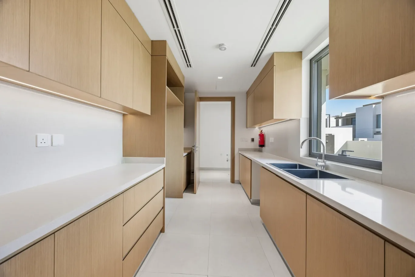 Wide view of the fitted kitchen with full height storage. Villa photography by MRPS in Dubai for ELITE Property Brokerage.