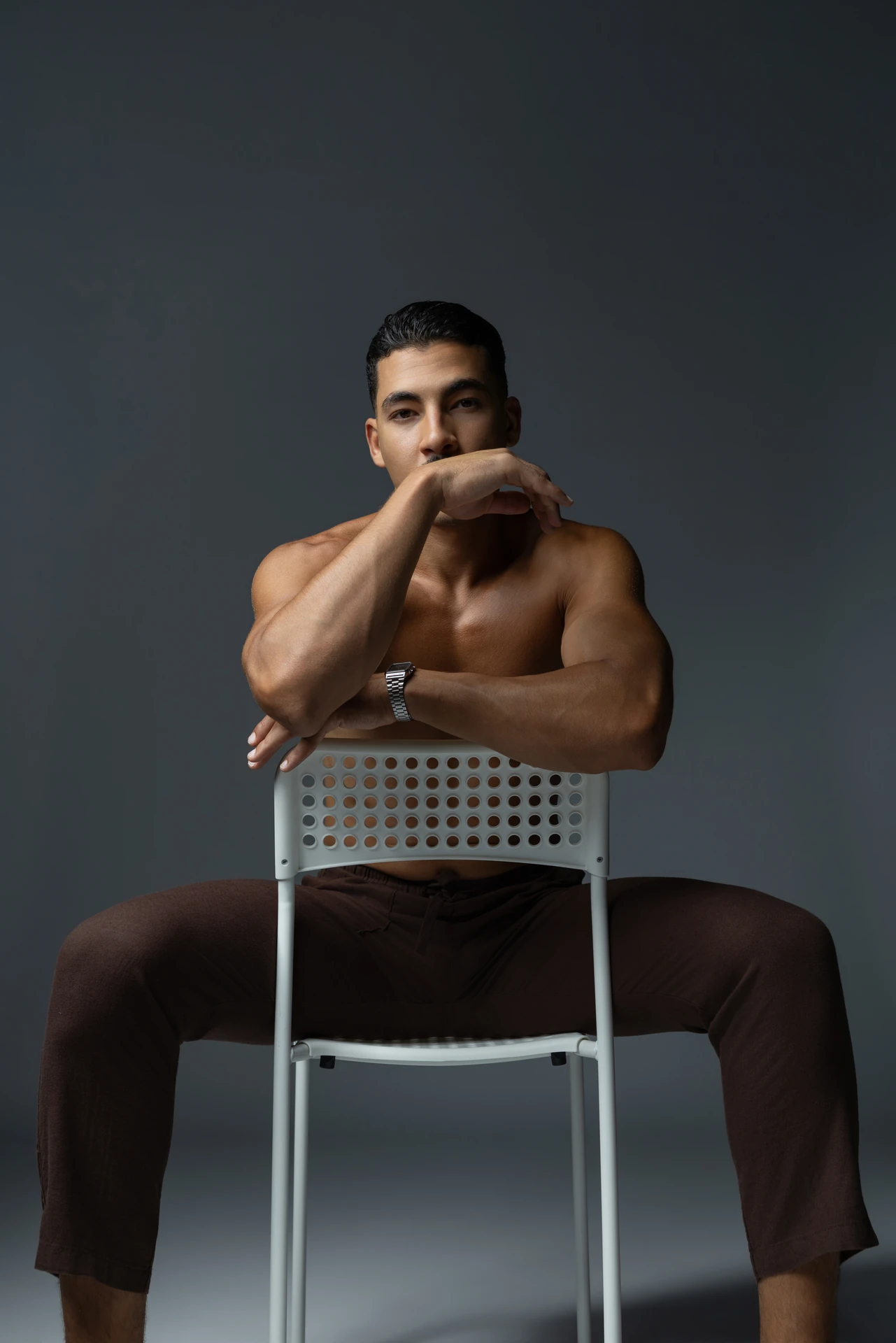 Seated backwards on a chair with the head resting on folded arms. Male modeling portfolio photoshoot by MRPS in Dubai, photographed by Nastaran.