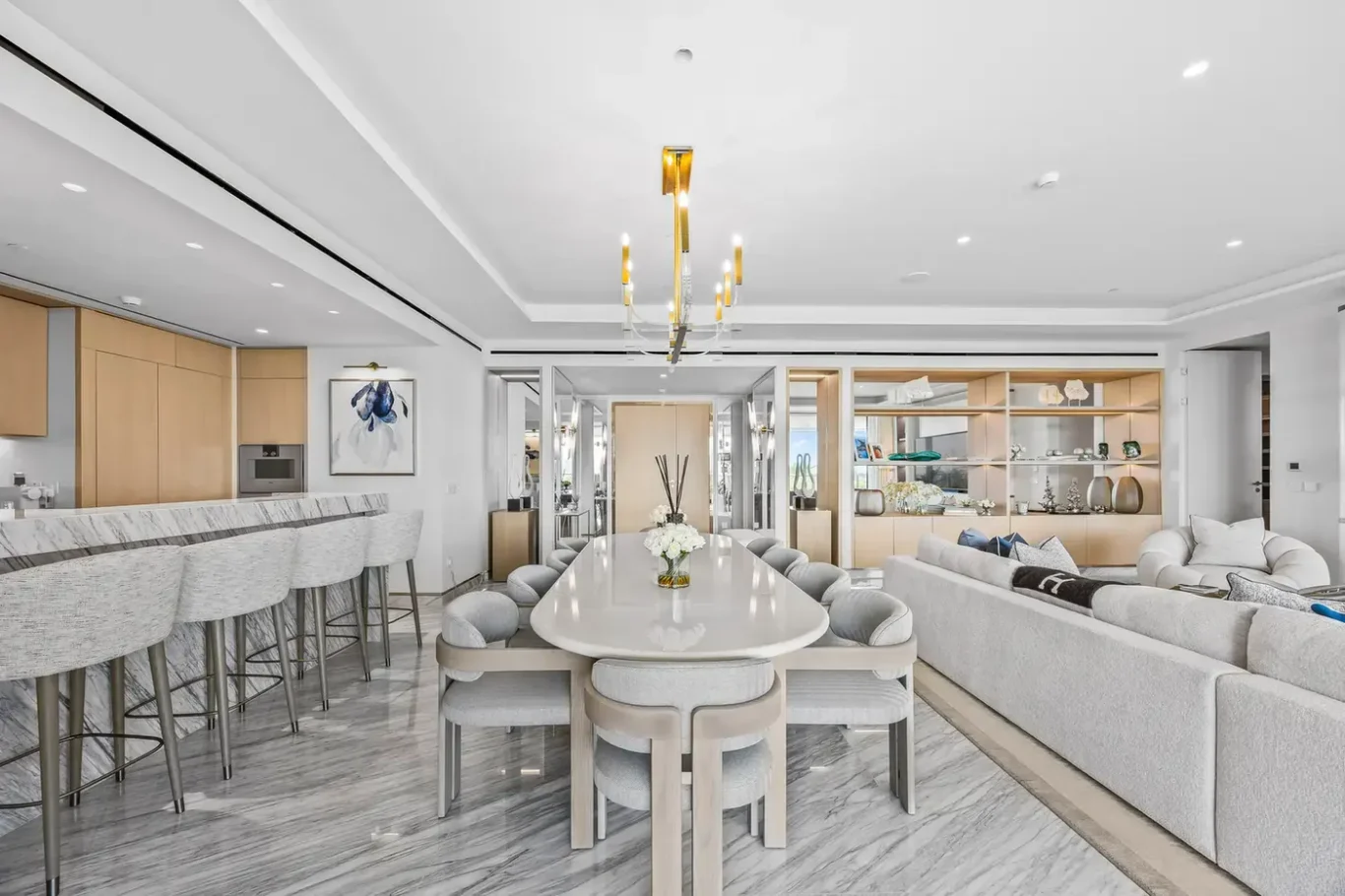 Kitchen island with bar stools beside the dining table in a furnished three-bedroom residence at Atlantis The Royal, Palm Jumeirah, photographed for Apex Homes Real Estate.