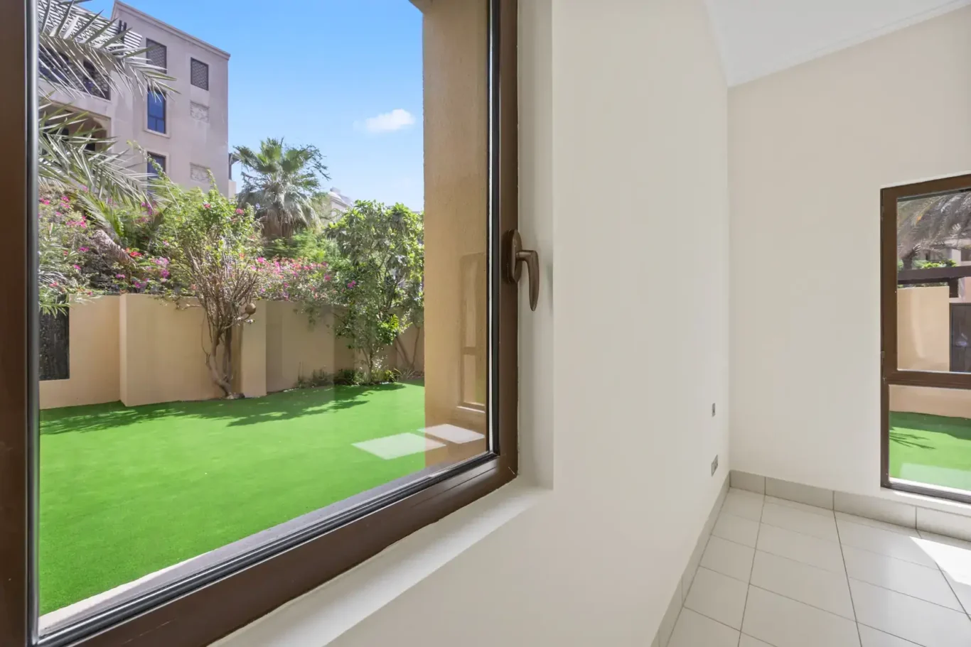 Garden and Old Town view through the window in an unfurnished two-bedroom garden apartment in Old Town, Downtown Dubai, photographed for ELITE Property Brokerage.