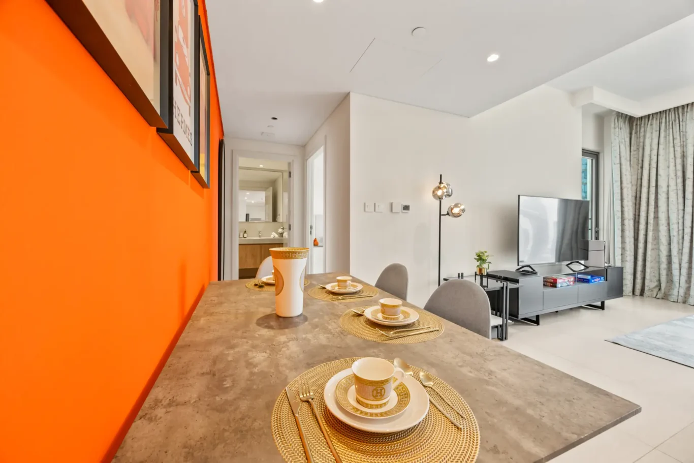 Hallway with orange wall leading from the living room to the bedrooms. Day, twilight and night Airbnb photography by MRPS for Vista Haus Holiday Homes in Downtown Dubai.