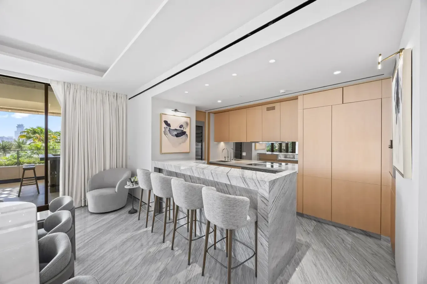 Kitchen with marble breakfast bar and wood cabinetry in a furnished three-bedroom residence at Atlantis The Royal, Palm Jumeirah, photographed for Apex Homes Real Estate.