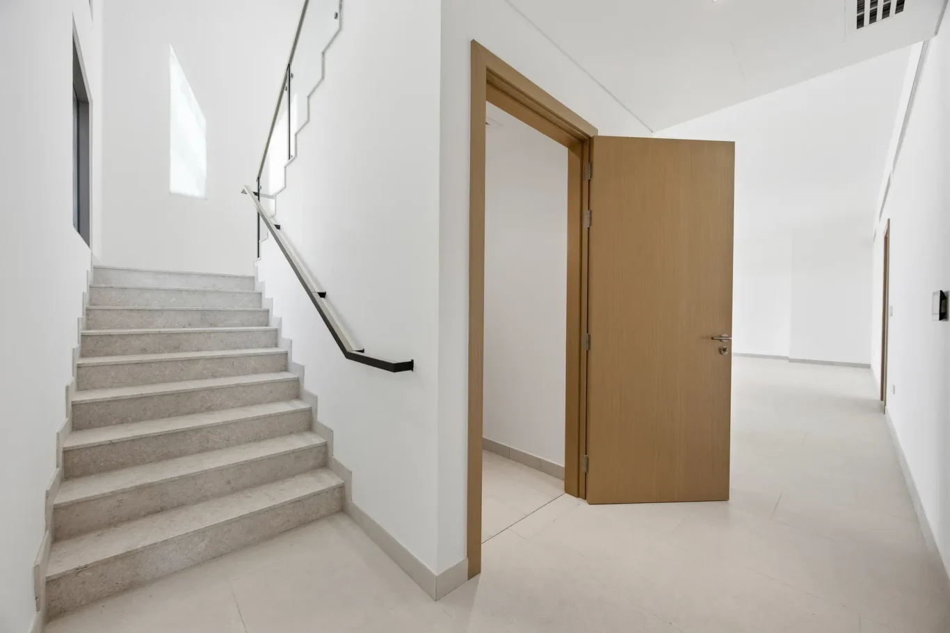 Staircase with glass balustrade to the first floor. Villa photography by MRPS in Dubai for ELITE Property Brokerage.
