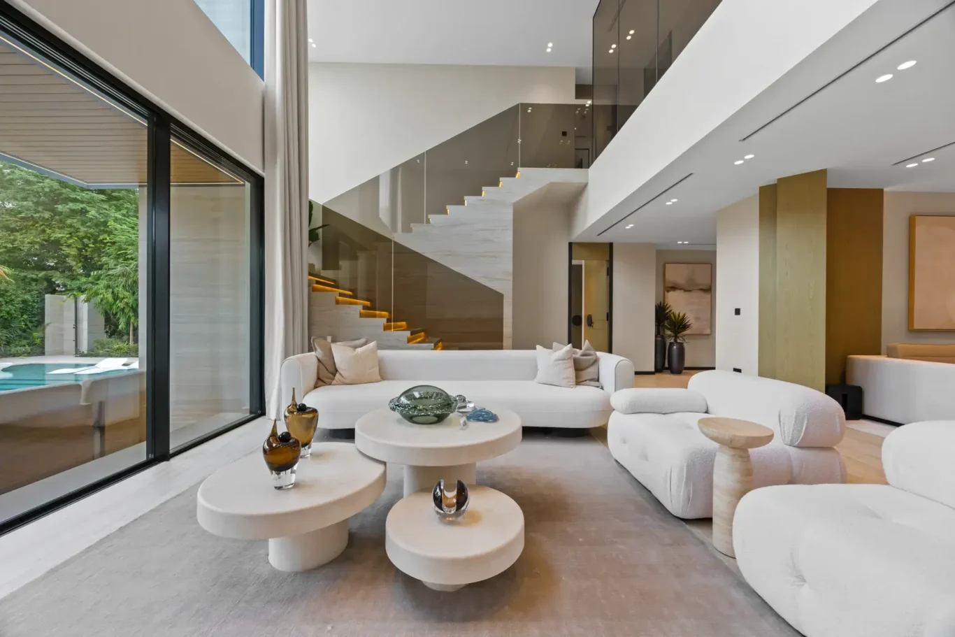 Living room seating with a view of the pool and the staircase behind, luxury villa in Jumeirah Islands, Dubai.