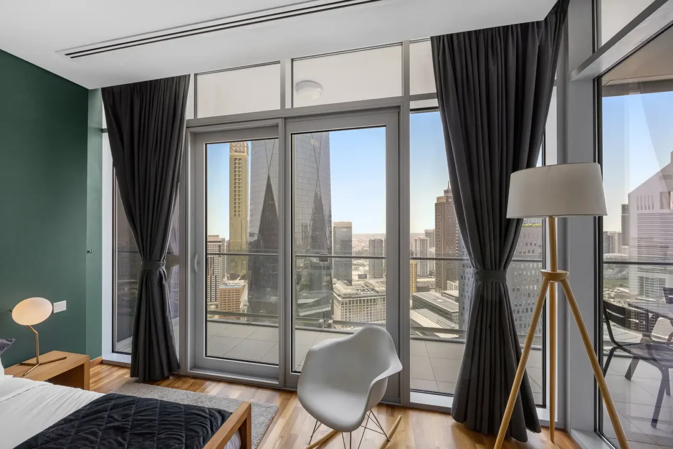 Bedroom window corner with lamp and chair in a Your Stay Apartments one-bedroom at Burj Daman, DIFC, Dubai.