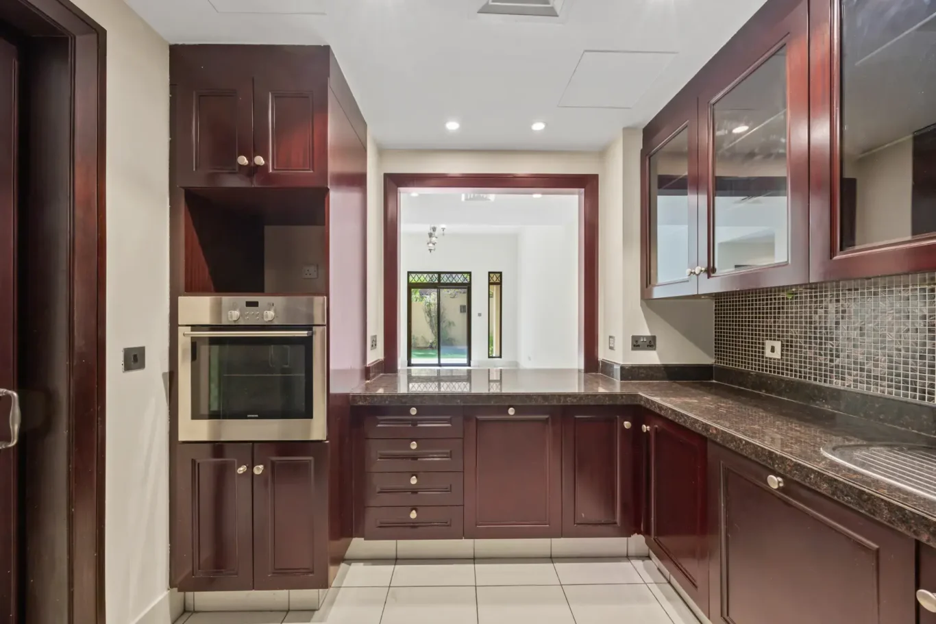 Kitchen with built-in oven and mosaic splashback in an unfurnished two-bedroom garden apartment in Old Town, Downtown Dubai, photographed for ELITE Property Brokerage.