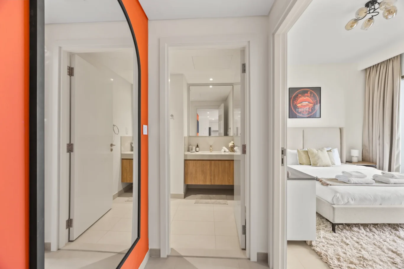 Master bedroom seen through the orange door frame with the ensuite bathroom. Day, twilight and night Airbnb photography by MRPS for Vista Haus Holiday Homes in Downtown Dubai.