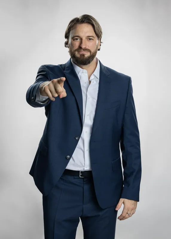 Pointing at the camera with a smile. White background reference photo from an AI model training photoshoot at the MRPS studio in Dubai.