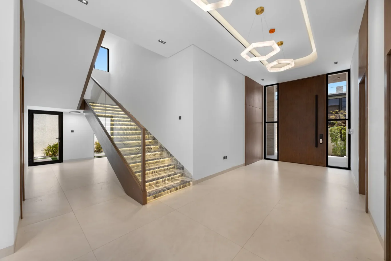 Marble staircase with lit steps and a glass balustrade, unfurnished five-bedroom villa in Al Furjan, Dubai.
