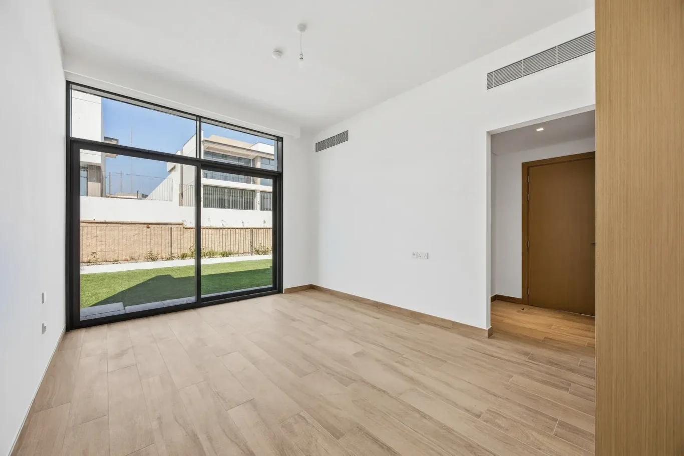 Ground floor bedroom with large window and timber door. Villa photography by MRPS in Dubai for ELITE Property Brokerage.