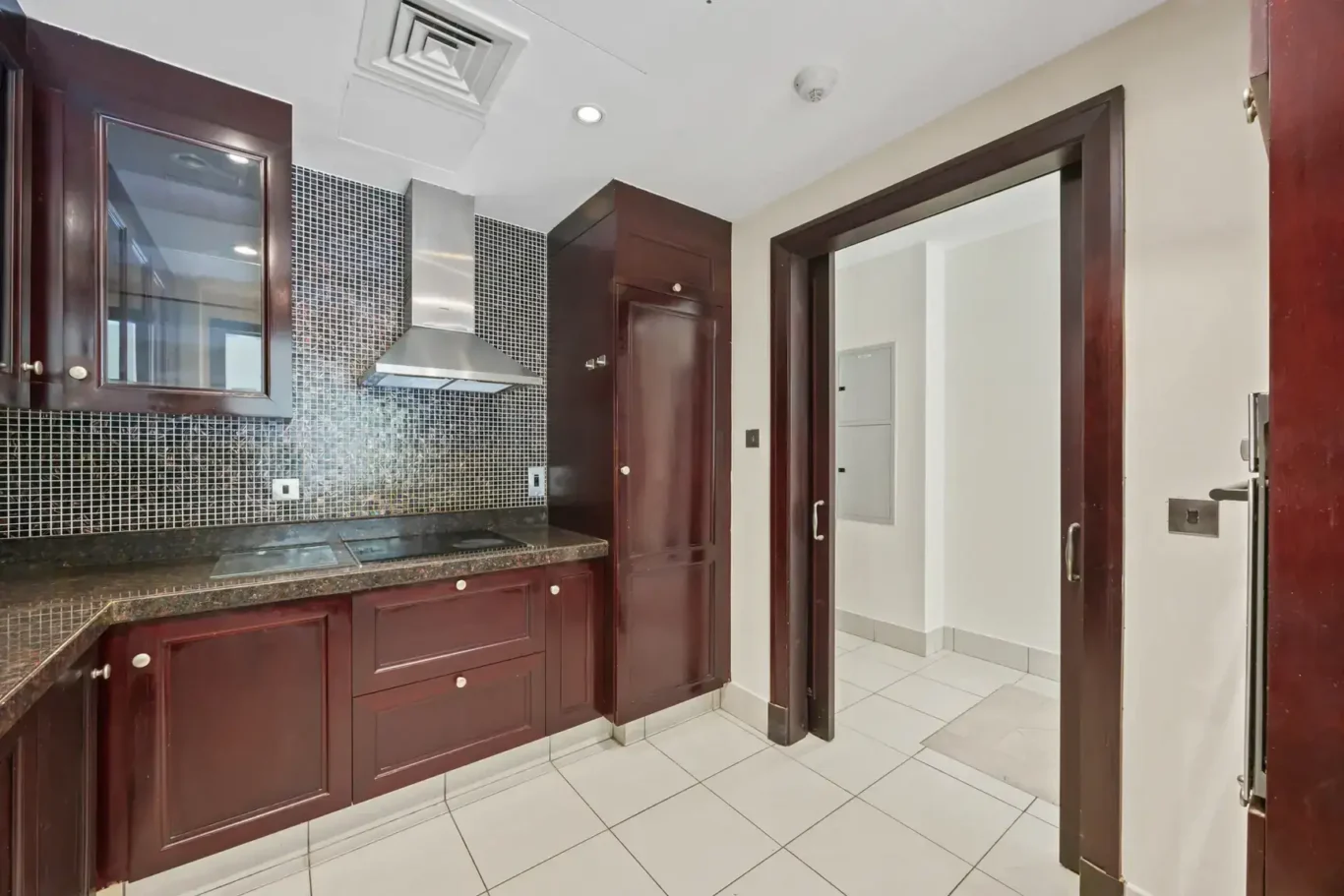 Kitchen cabinets, hob and extractor in an unfurnished two-bedroom garden apartment in Old Town, Downtown Dubai, photographed for ELITE Property Brokerage.