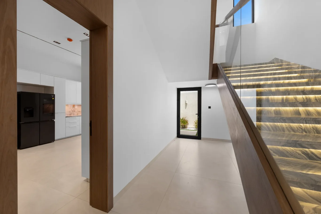 Staircase with a view through to the kitchen, unfurnished five-bedroom villa in Al Furjan, Dubai.
