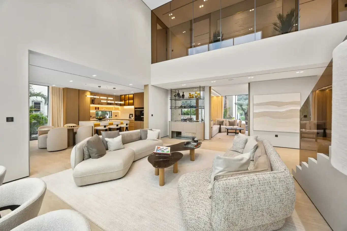 Wide view of the dining and living areas with the mezzanine above, luxury villa in Jumeirah Islands, Dubai.