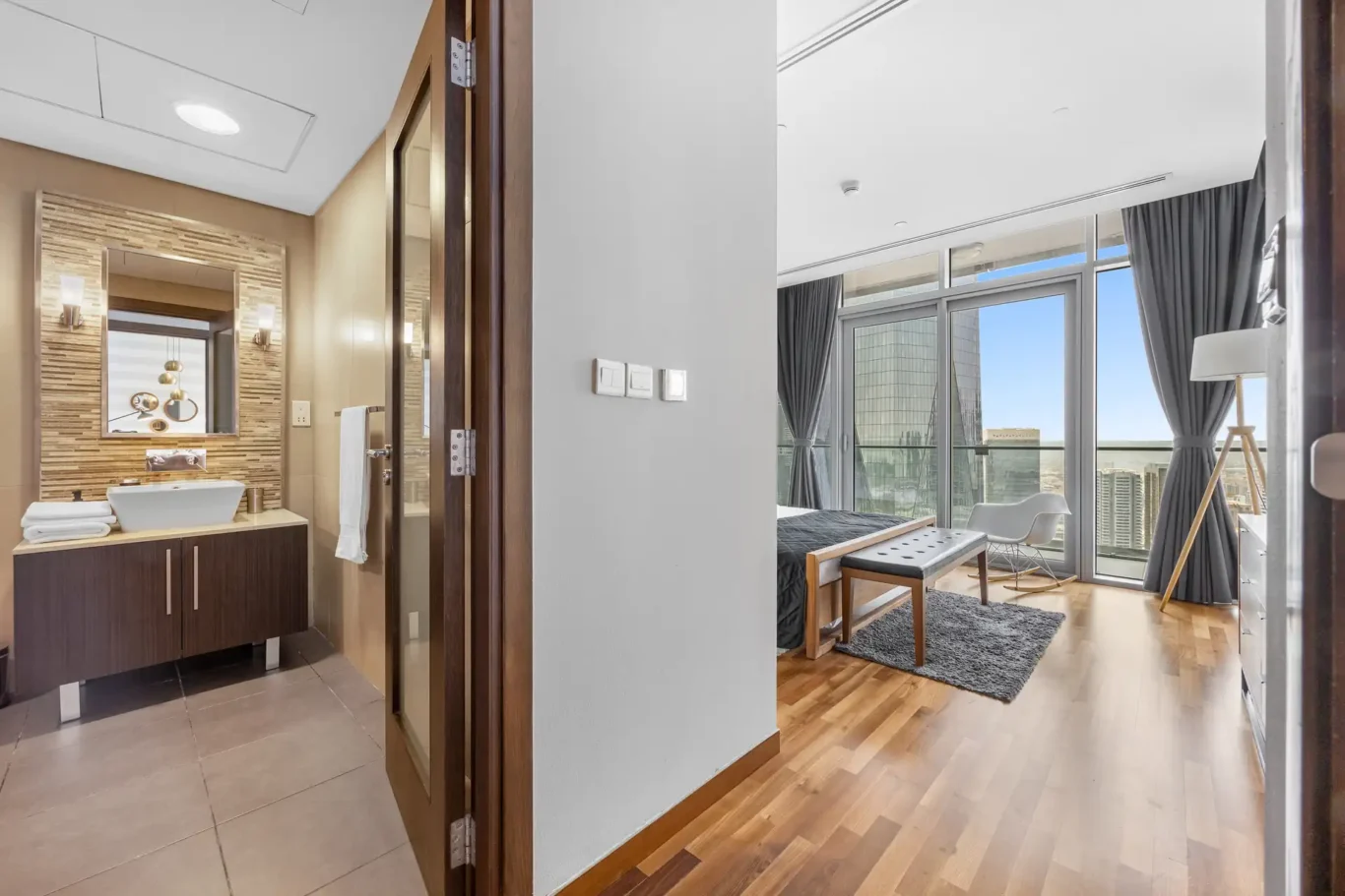En suite bathroom entrance with stone feature wall in a Your Stay Apartments one-bedroom at Burj Daman, DIFC, Dubai.