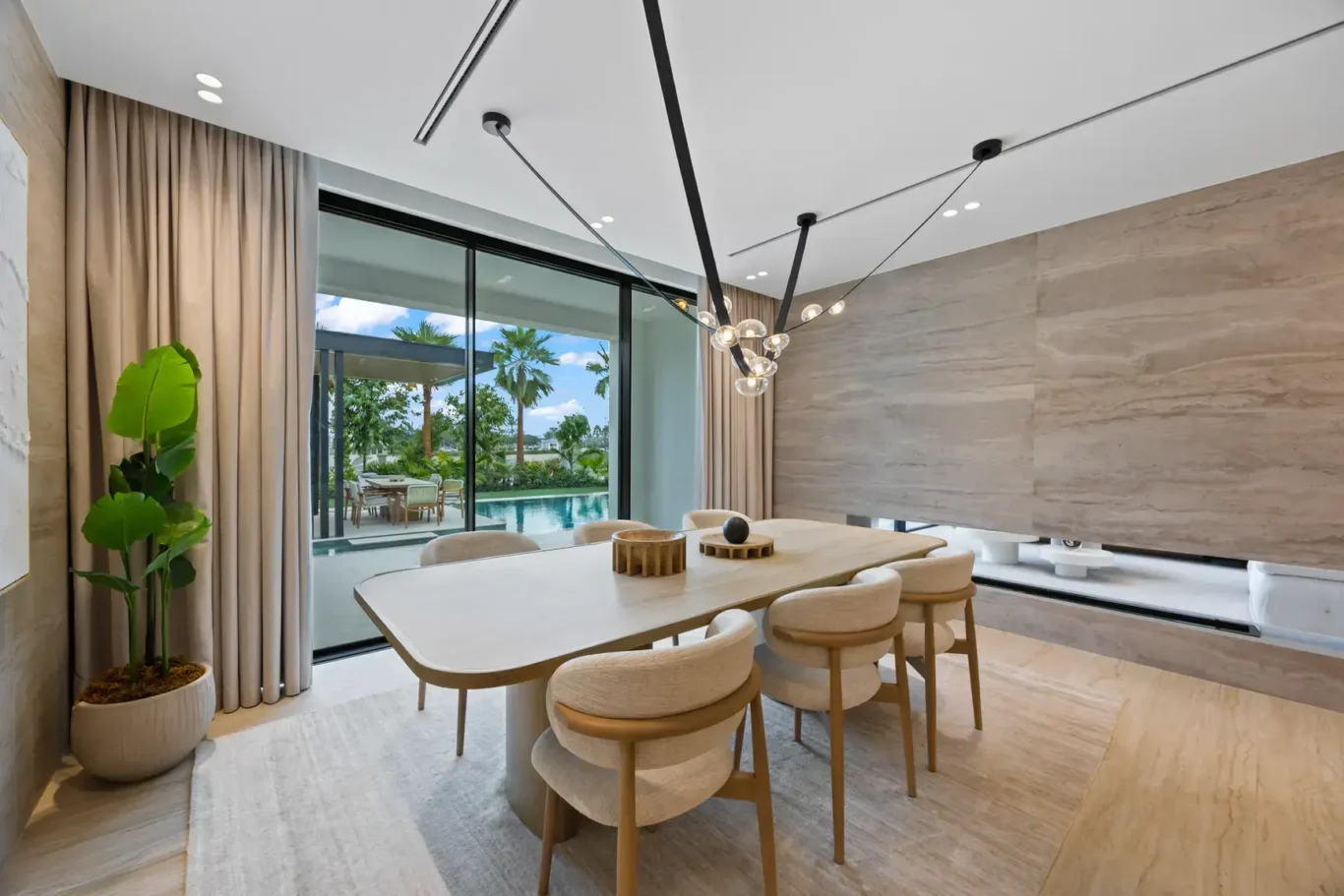 Dining area with a table for eight and a sculptural chandelier, luxury villa in Jumeirah Islands, Dubai.
