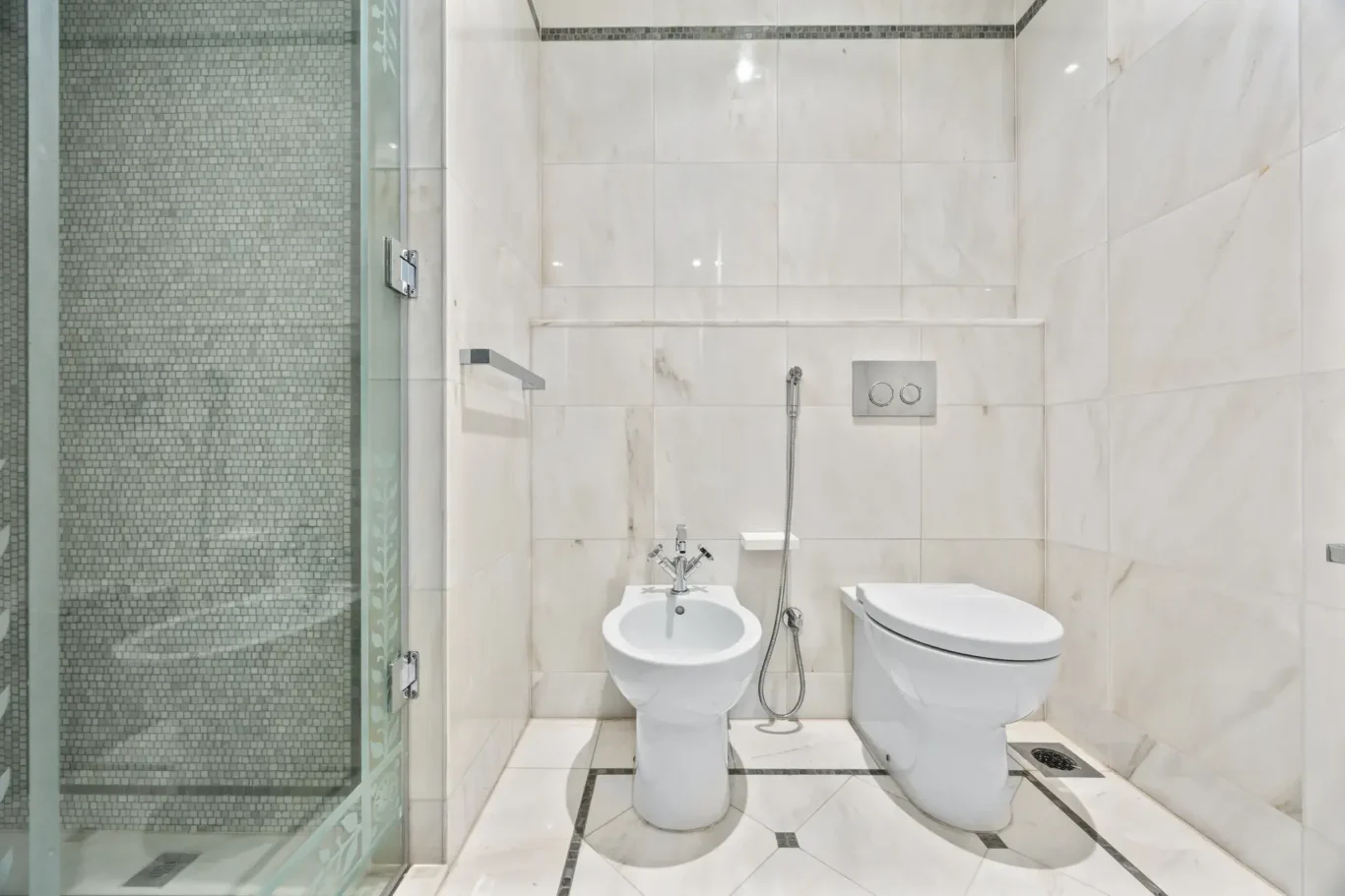 Marble bathroom with WC, bidet and glass shower in a three-bedroom residence at Palazzo Versace Dubai, Jaddaf Waterfront, photographed for Concierge Auctions.