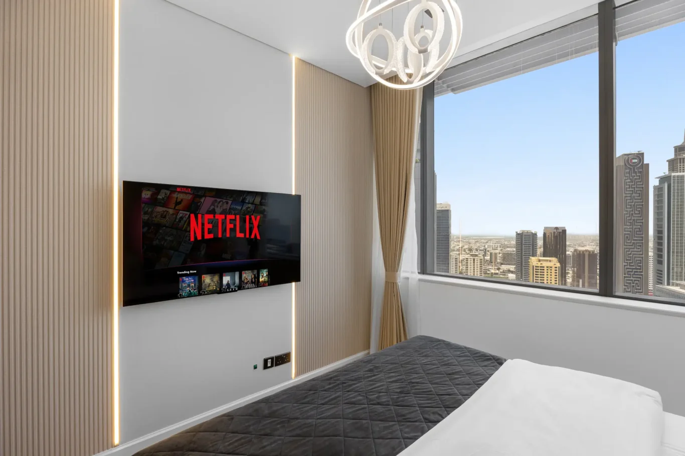 Bedroom TV wall and window in a Your Stay Apartments one-bedroom at Sky Gardens, DIFC, Dubai.