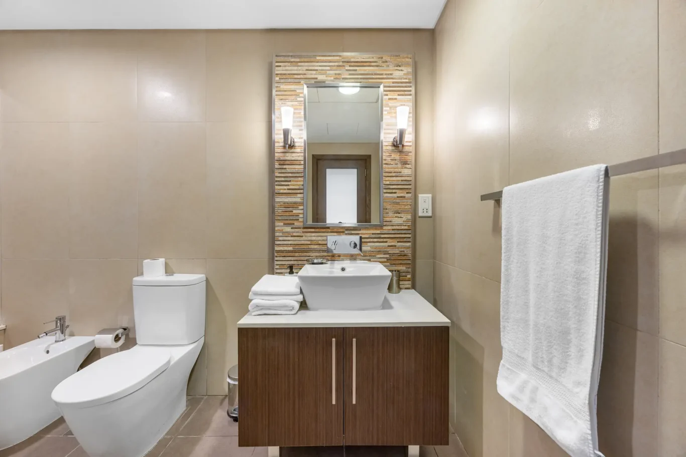 Bathroom vanity with stone mosaic mirror wall in a Your Stay Apartments one-bedroom at Burj Daman, DIFC, Dubai.