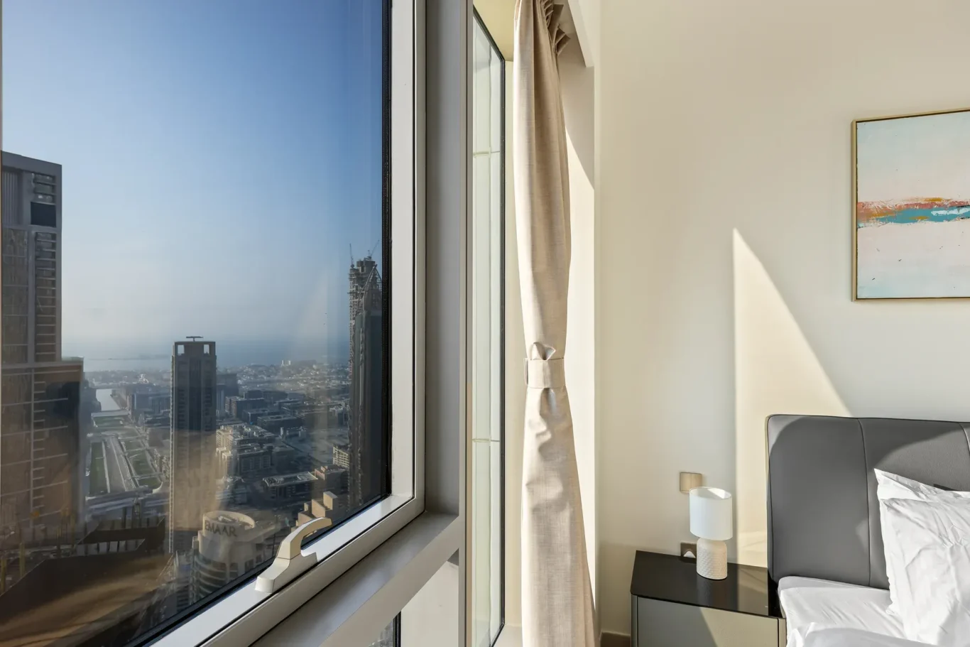 Bedroom window with city view next to the bed. Airbnb photography by MRPS for Solea Stay in Dubai.