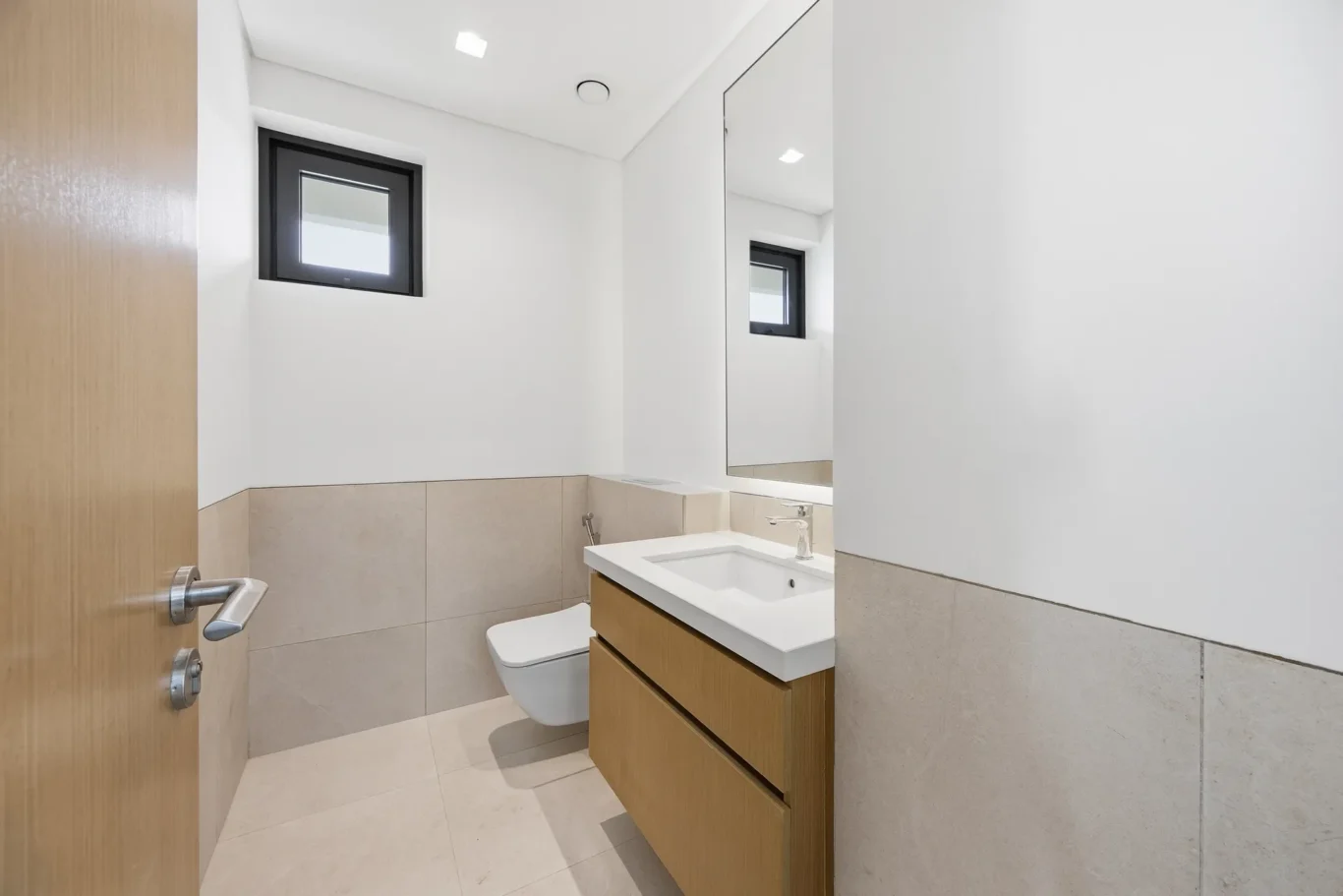 Guest bathroom with timber vanity and wall hung toilet. Villa photography by MRPS in Dubai for ELITE Property Brokerage.