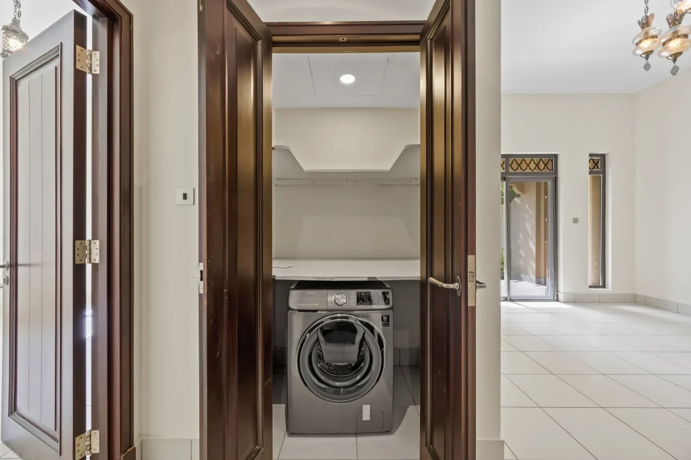 Laundry cupboard with washing machine in an unfurnished two-bedroom garden apartment in Old Town, Downtown Dubai, photographed for ELITE Property Brokerage.