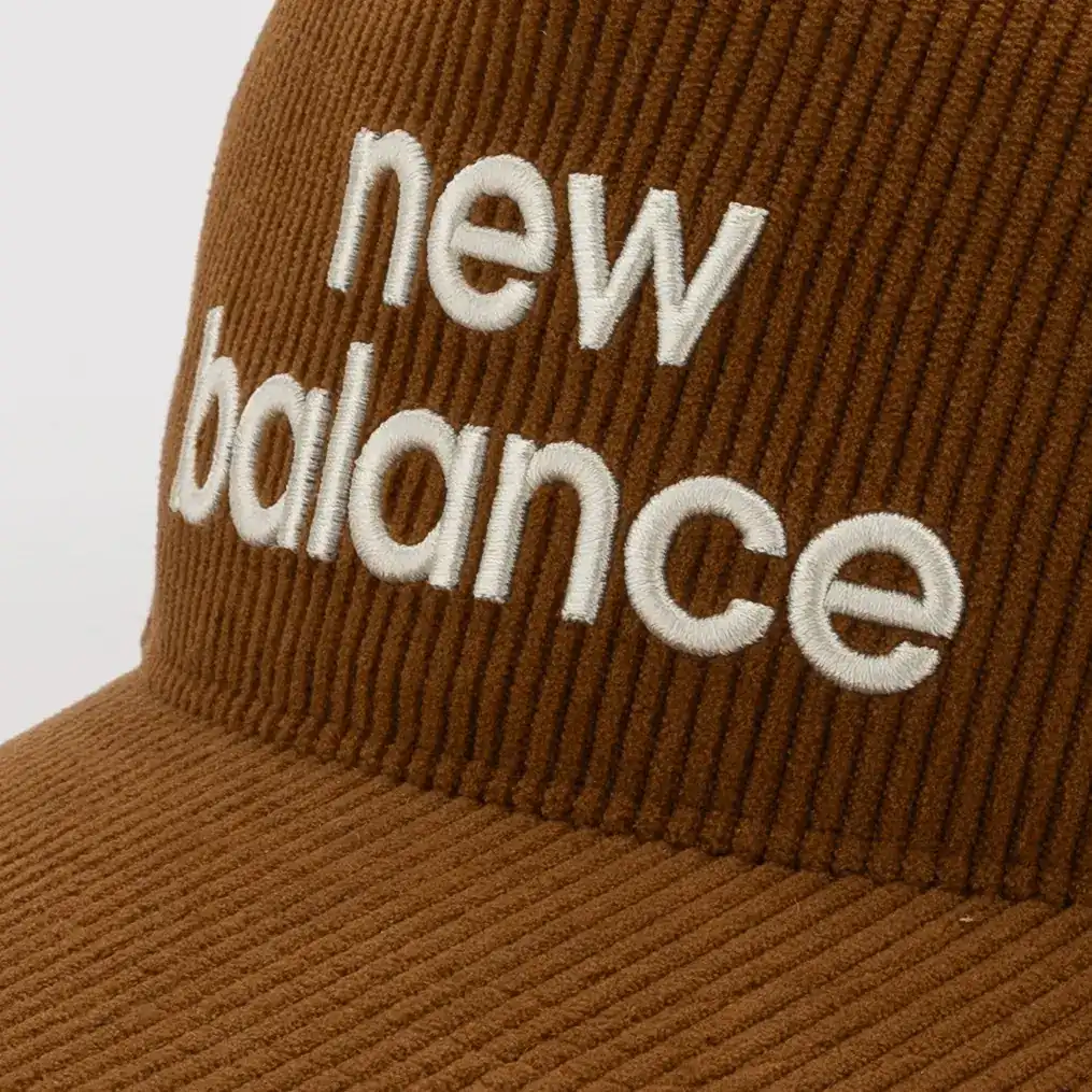 Close-up of the corduroy texture and stitched logo on the brown New Balance cap. E-commerce product photography for New Balance by MRPS in Dubai.