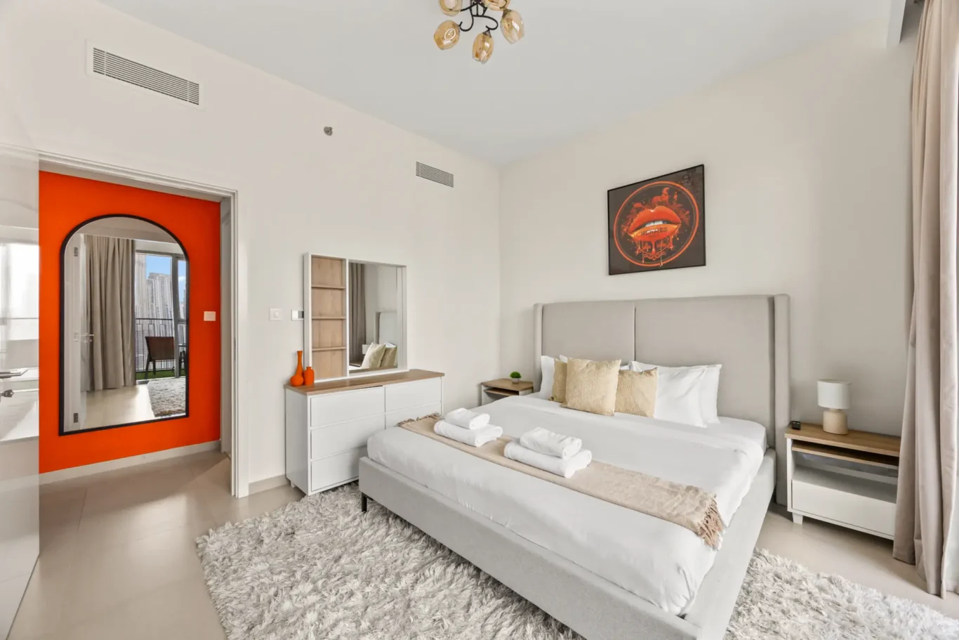 Master bedroom with arched orange TV niche and king bed. Day, twilight and night Airbnb photography by MRPS for Vista Haus Holiday Homes in Downtown Dubai.