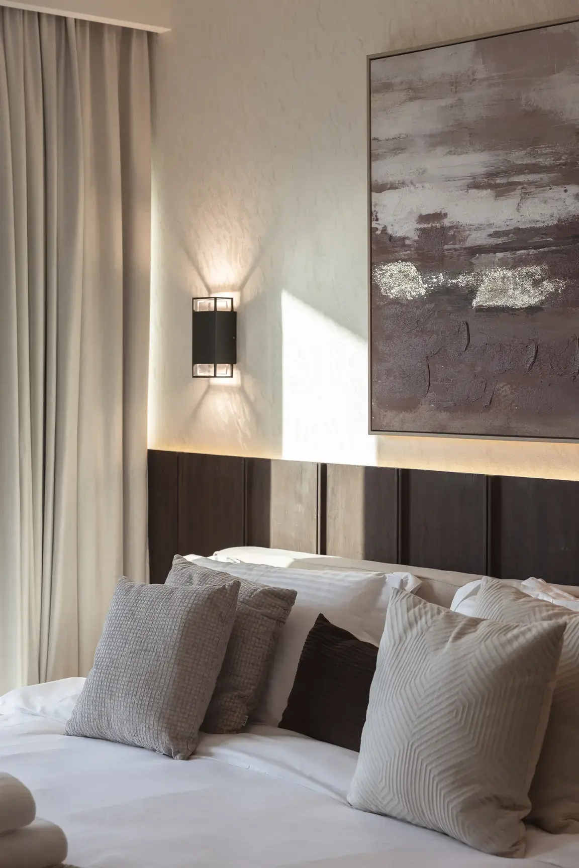 Master bedroom with wooden wall panels, LED cove light and abstract art. Interior design photography for Aziza Home by MRPS in Dubai.