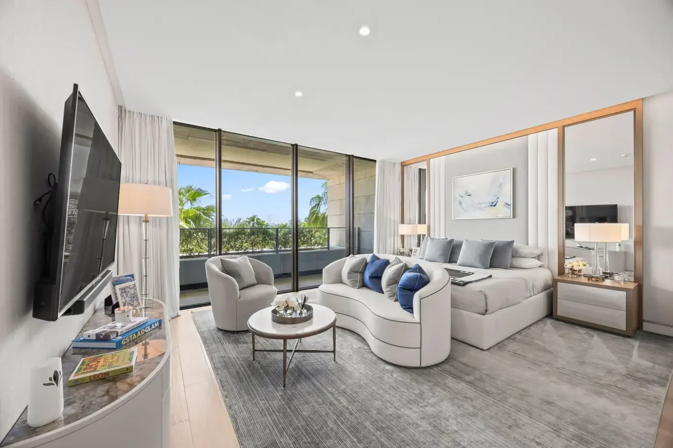 Master suite with sitting area, curved sofa and garden view in a furnished three-bedroom residence at Atlantis The Royal, Palm Jumeirah, photographed for Apex Homes Real Estate.