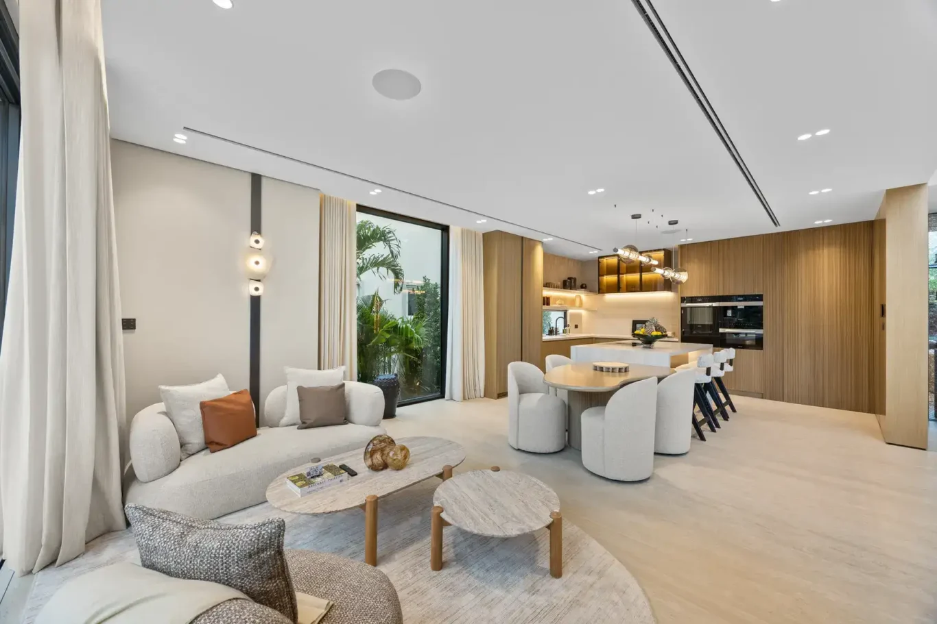 Family sitting area with the kitchen dining table behind, luxury villa in Jumeirah Islands, Dubai.