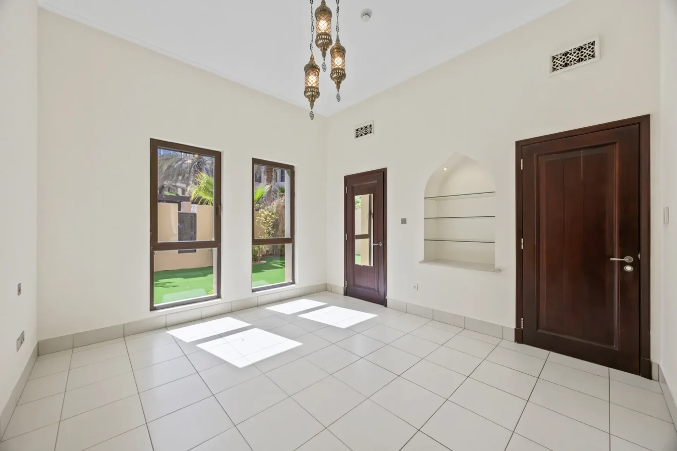 Master bedroom with arched niche and wooden doors in an unfurnished two-bedroom garden apartment in Old Town, Downtown Dubai, photographed for ELITE Property Brokerage.
