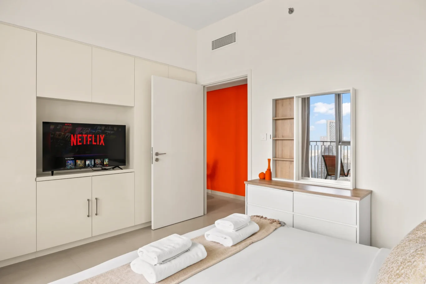 Master bedroom with TV, wardrobe and city view windows. Day, twilight and night Airbnb photography by MRPS for Vista Haus Holiday Homes in Downtown Dubai.