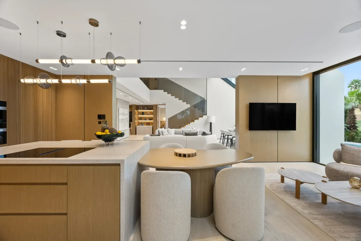 Kitchen island and breakfast table with pendant lights, luxury villa in Jumeirah Islands, Dubai.