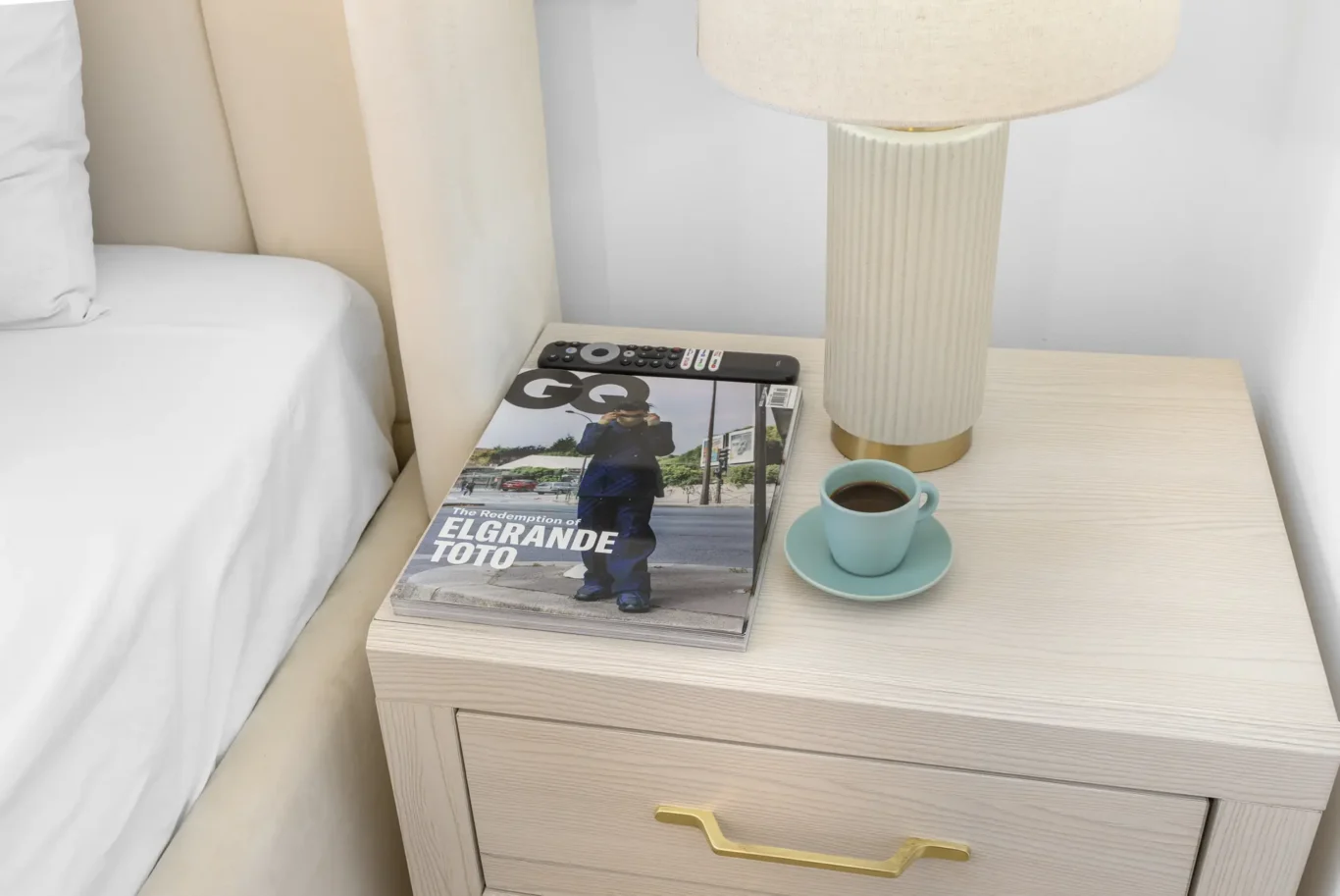 Bedside table with lamp and coffee cup in a Your Stay Apartments one-bedroom at Sky Gardens, DIFC, Dubai.