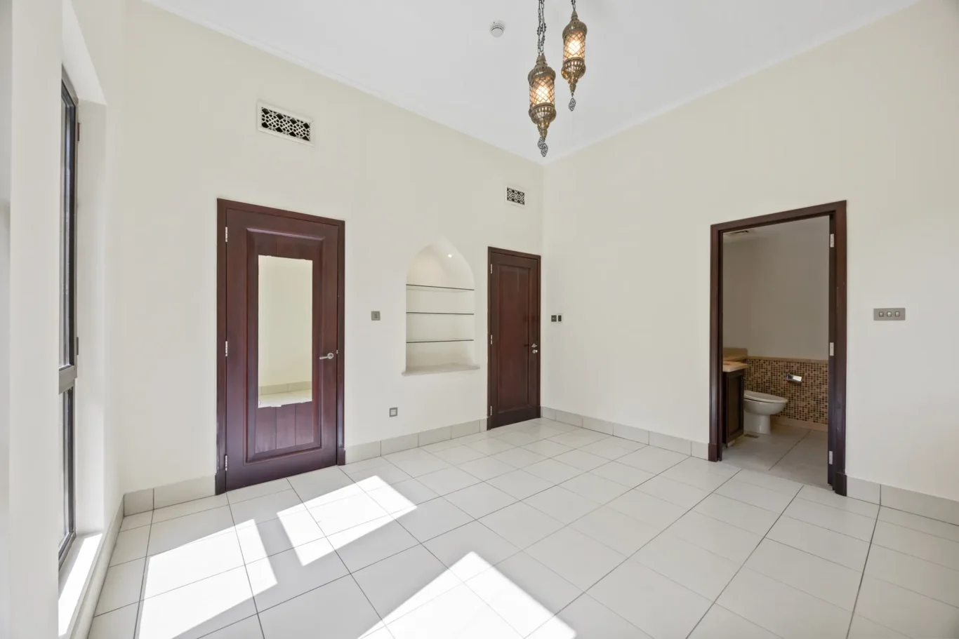 Master bedroom with door to the en suite in an unfurnished two-bedroom garden apartment in Old Town, Downtown Dubai, photographed for ELITE Property Brokerage.