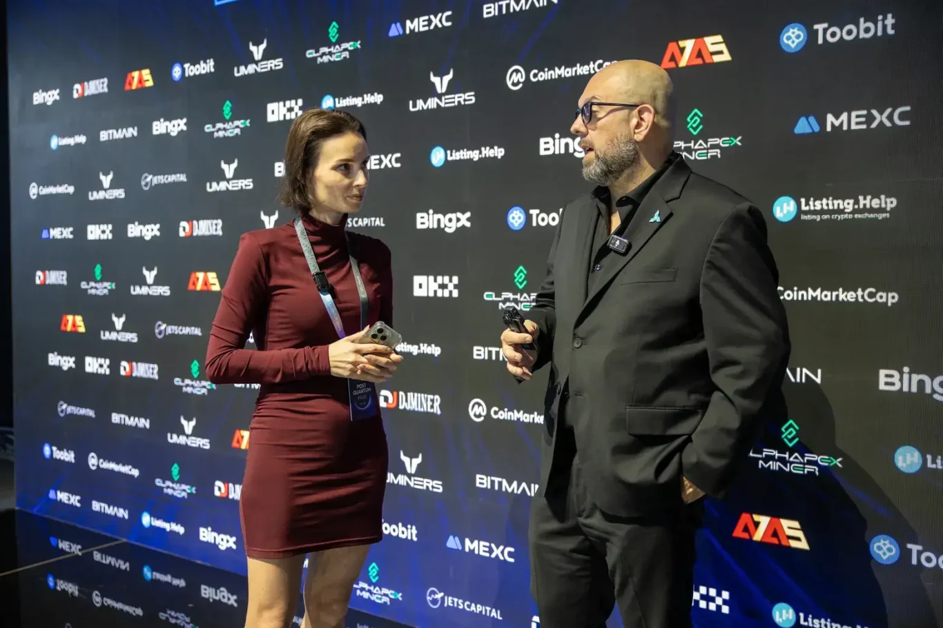 Interview in front of the sponsor wall. Event photography by MRPS at Blockchain Life 2025, Festival Arena, Dubai.