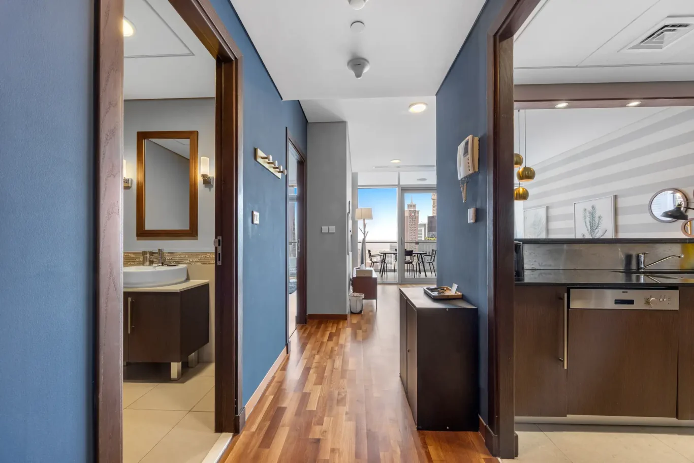 Entrance hall with wood floor and view to the living room in a Your Stay Apartments one-bedroom at Burj Daman, DIFC, Dubai.