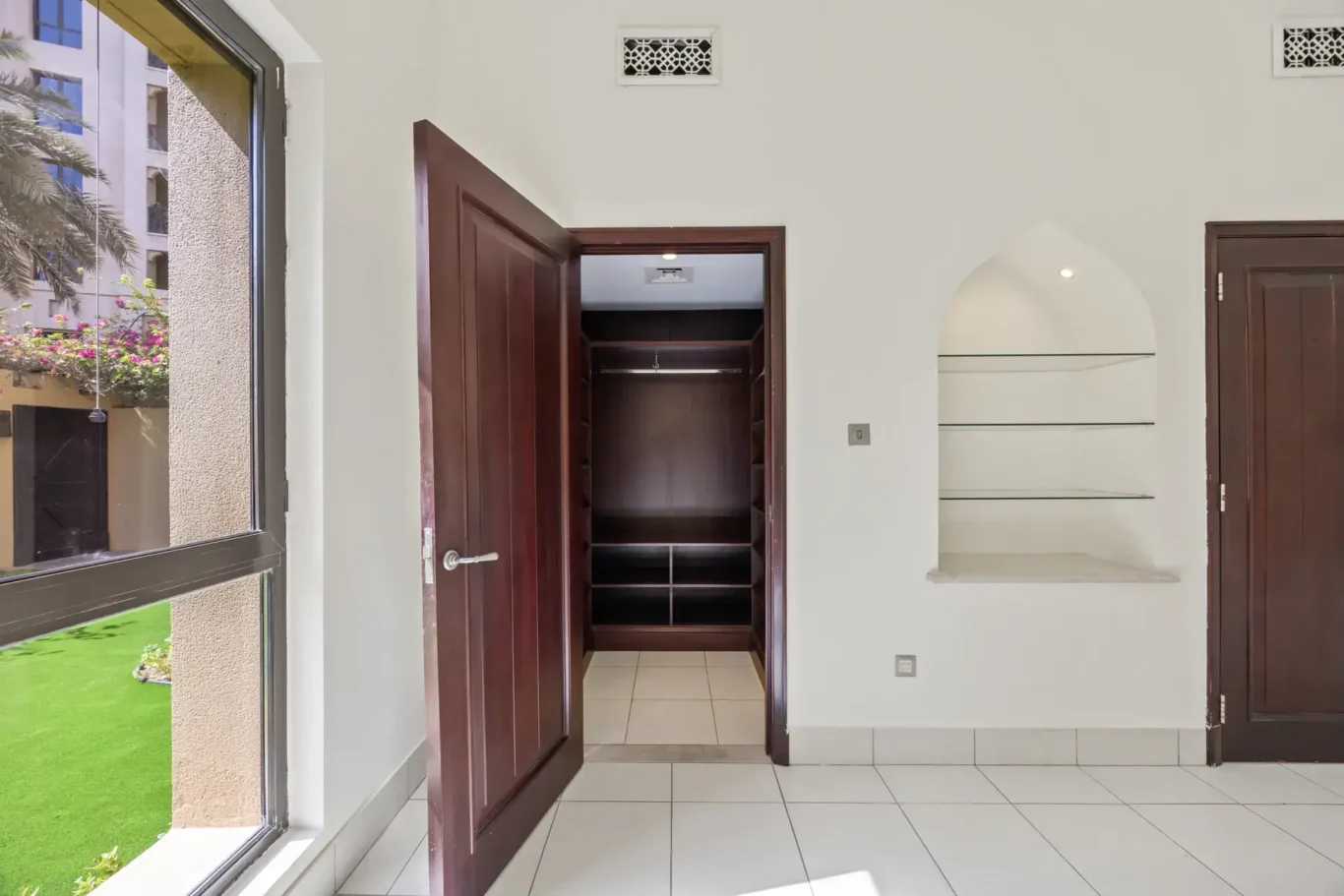 Master bedroom with direct garden access in an unfurnished two-bedroom garden apartment in Old Town, Downtown Dubai, photographed for ELITE Property Brokerage.