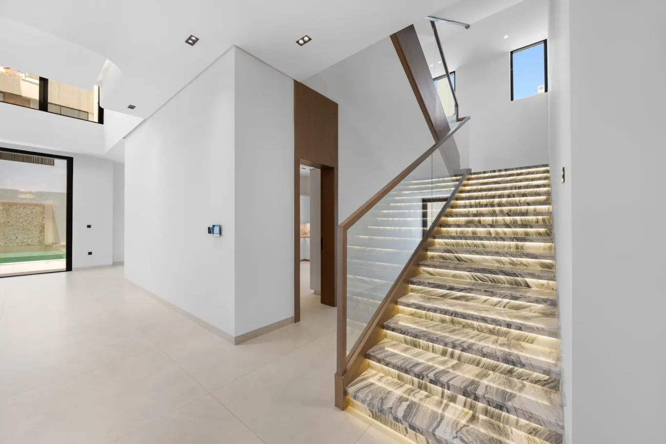 Marble staircase with lit steps seen from the hall, unfurnished five-bedroom villa in Al Furjan, Dubai.
