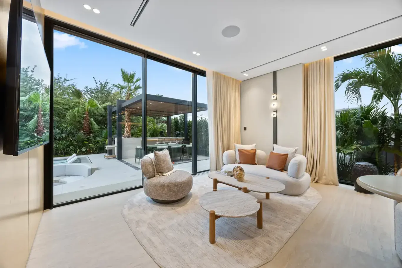 Family lounge opening onto the garden terrace, luxury villa in Jumeirah Islands, Dubai.
