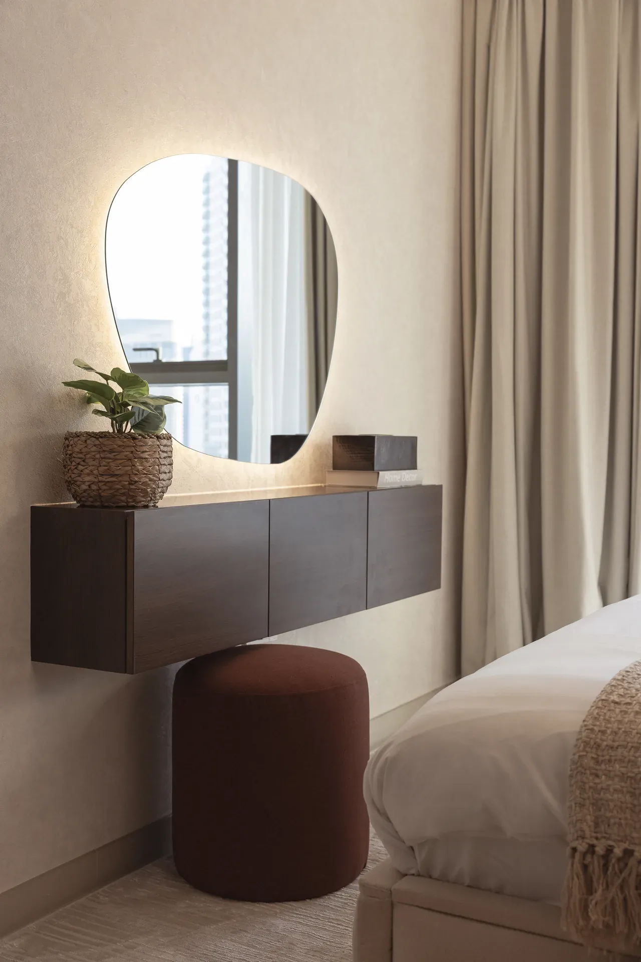 Floating dressing table with an organic shaped mirror and rust stool. Interior design photography for Aziza Home by MRPS in Dubai.