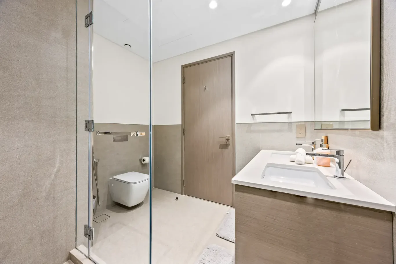 Ensuite bathroom with stone tiles and wall hung toilet. Airbnb photography by MRPS for Solea Stay in Dubai.
