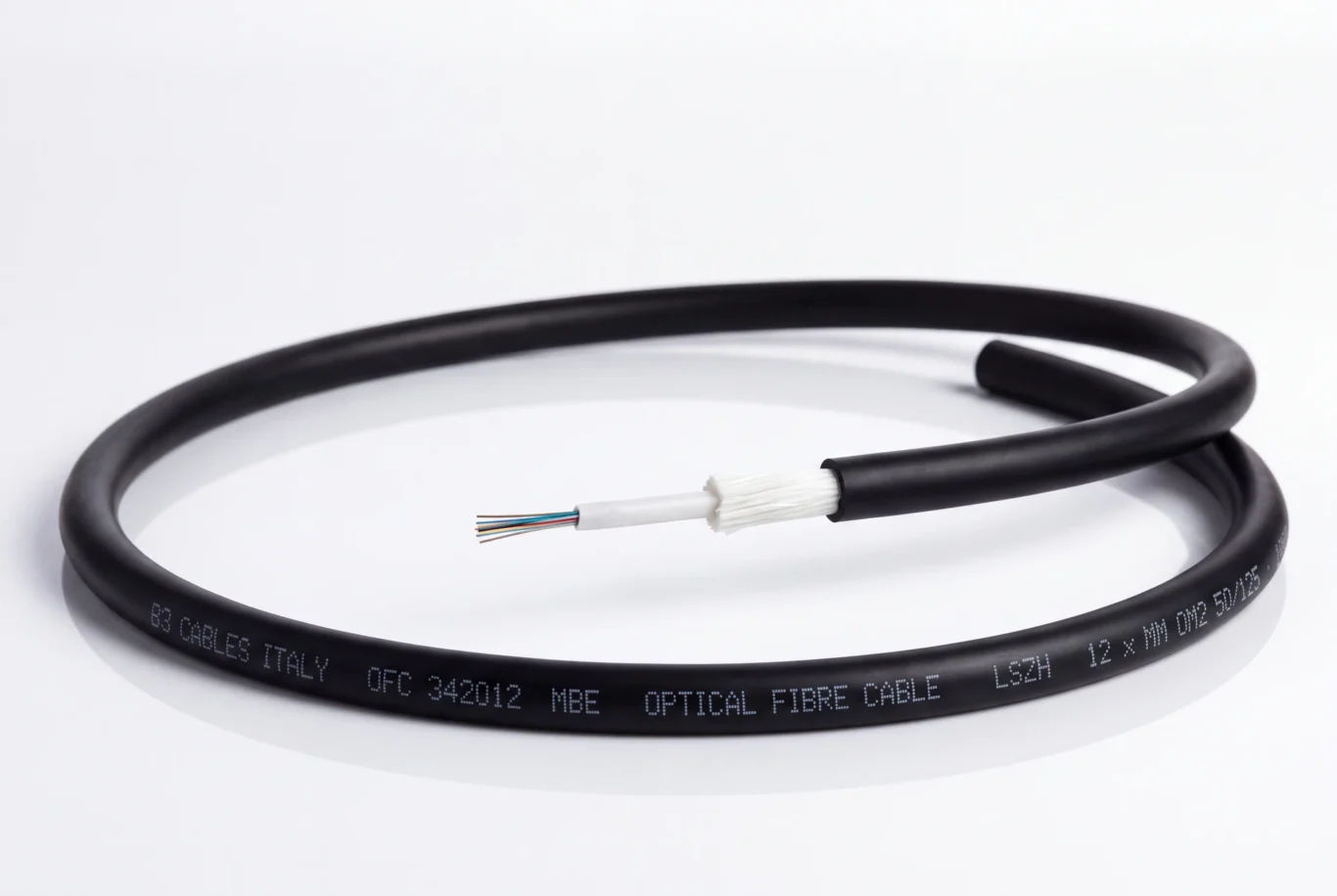 Studio product photo of a coiled black B3 International optical fibre cable with printed jacket and exposed fibres.