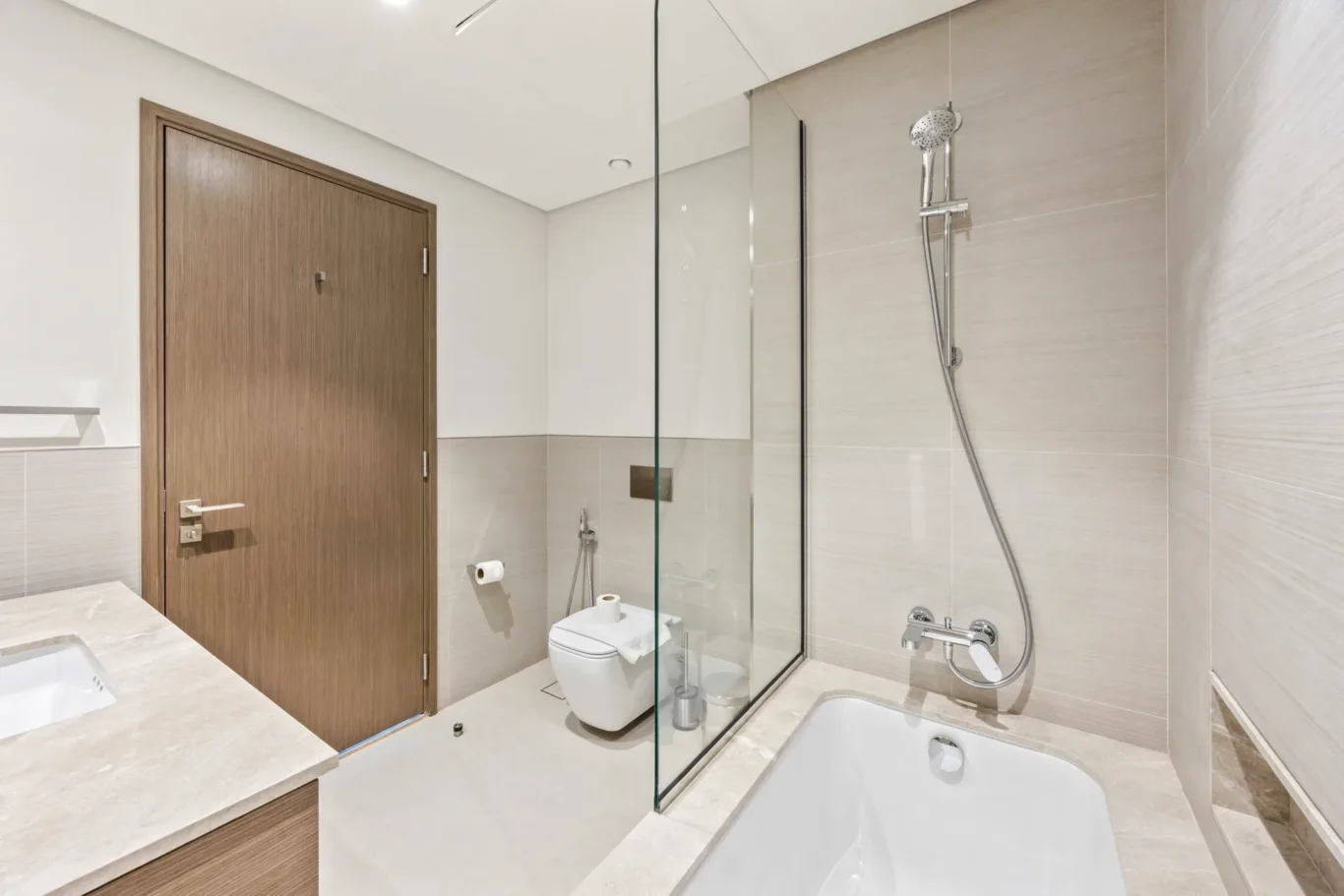 Bathroom with shower and bathtub in a two-bedroom StayComfy Holiday Homes apartment at Grande Signature, Downtown Dubai.